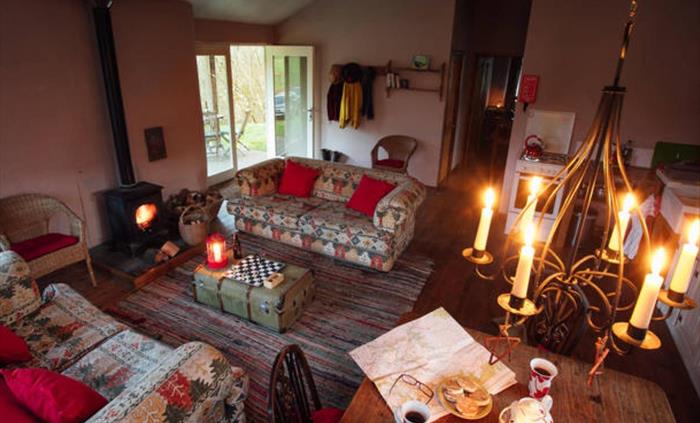 Comfy sofas, dining table, kitchen area, woodburner & candles. Just a step through the French doors and  you are on the veranda with views and the sou